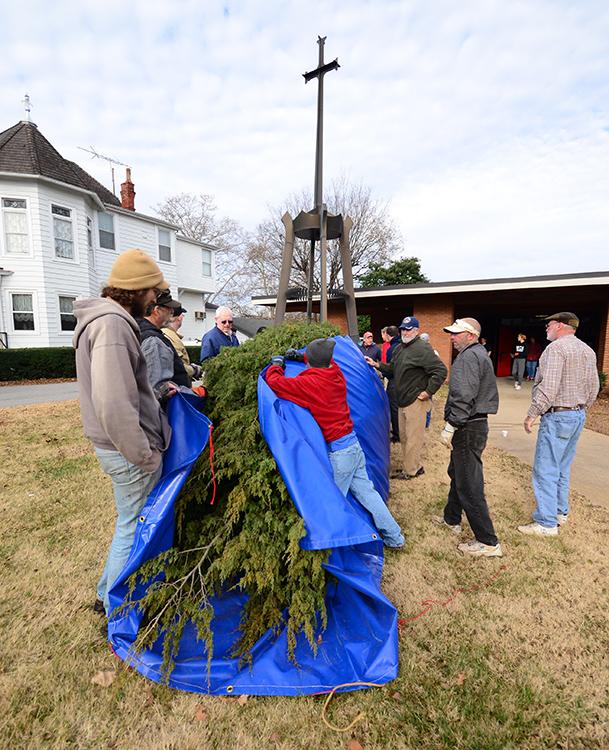 Volunteers gather to move the Chrismons tree indoors.