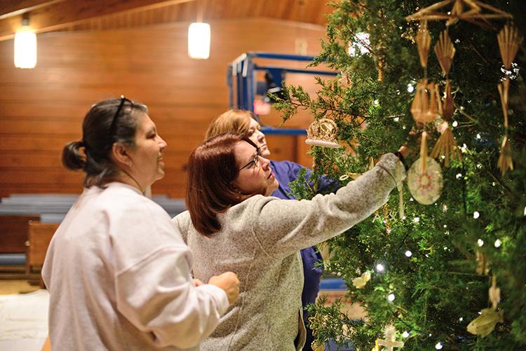 Elva Wasson, Kate Albright and Cindy Bailey work together on hanging and arranging ornaments during one of the installation shifts.