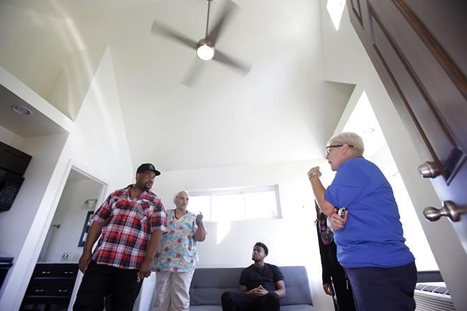 Stacy Conwell-Leigh of Cass Community Social Services (right, in blue shirt) talks to visitors inside the first tiny home.