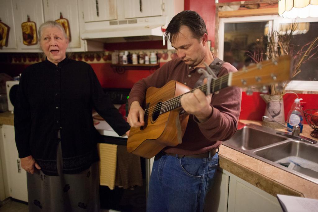 Mack strums his guitar while his mother, Vickie "Snook" Haywood, sings along during an evening Bible study in Bluefield, West Virginia.