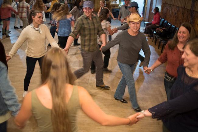 Dancers of all ages circle to the left at the square dance.