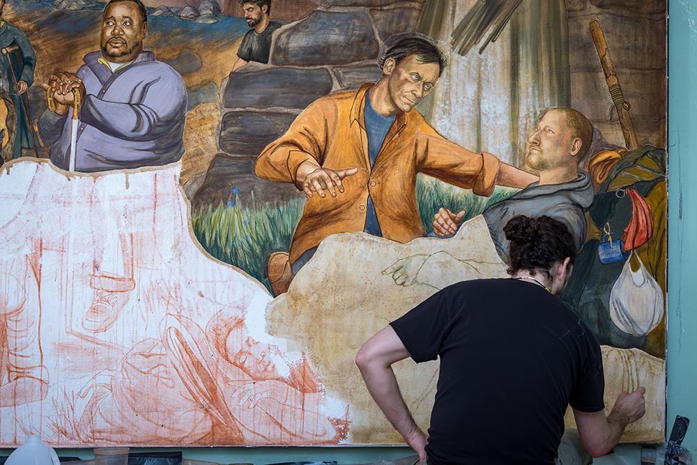 Christopher Holt painting a likeness of a Haywood Street employee on the final fresco.