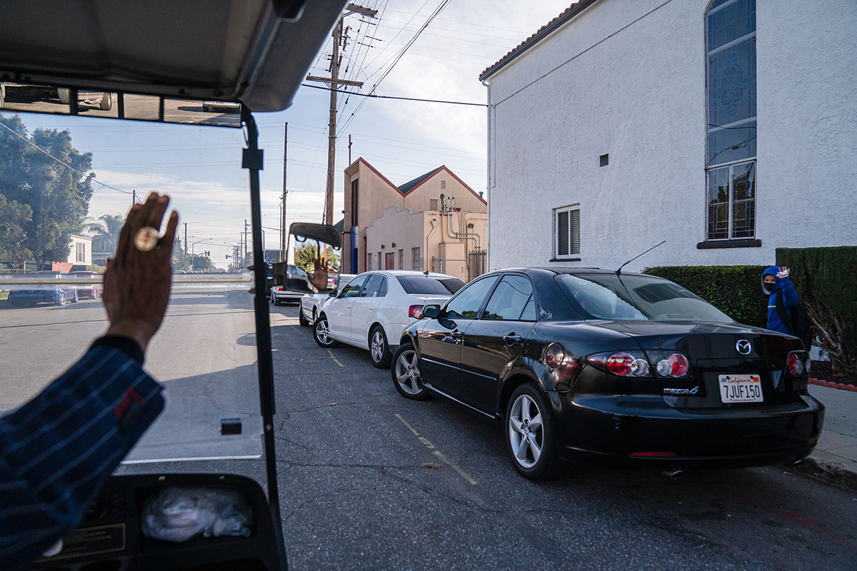 Man waves from golf cart