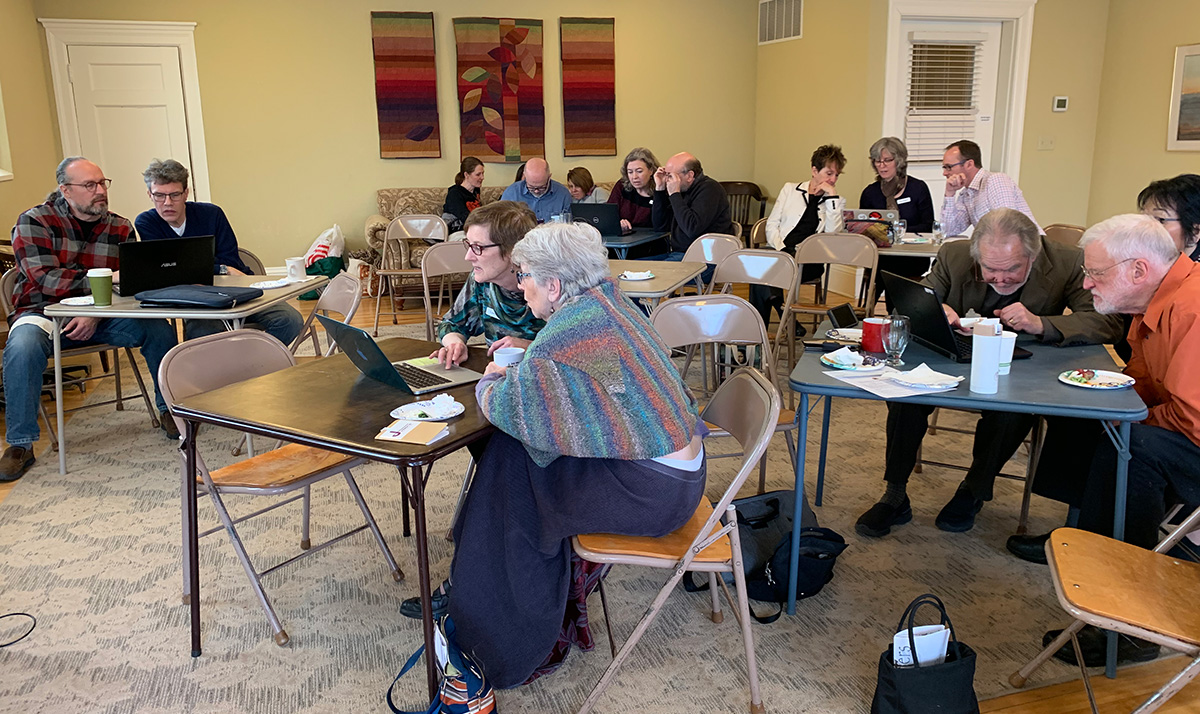 people gathering around laptop to review data