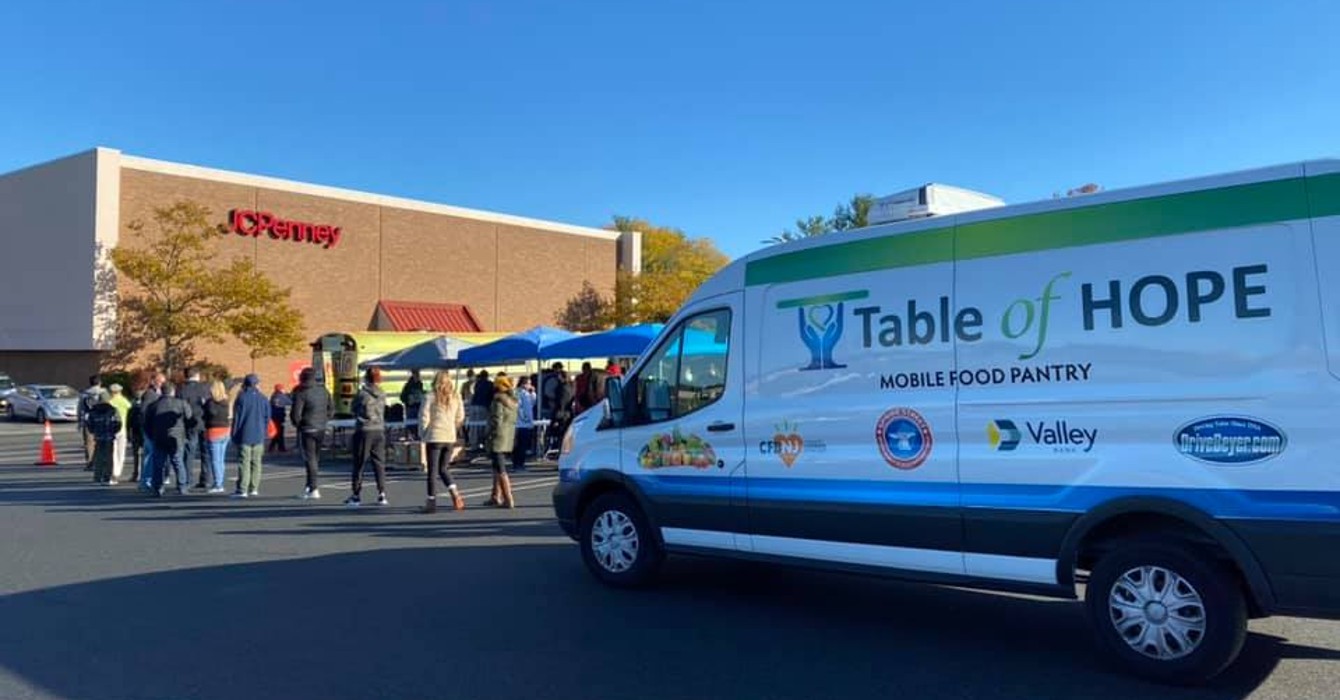 image of a food ministry van and line of people