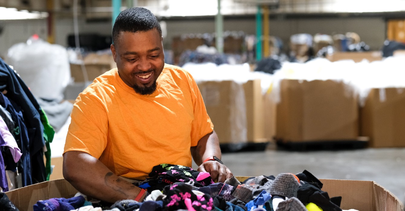 Photo of a man sorting clothing in a factory