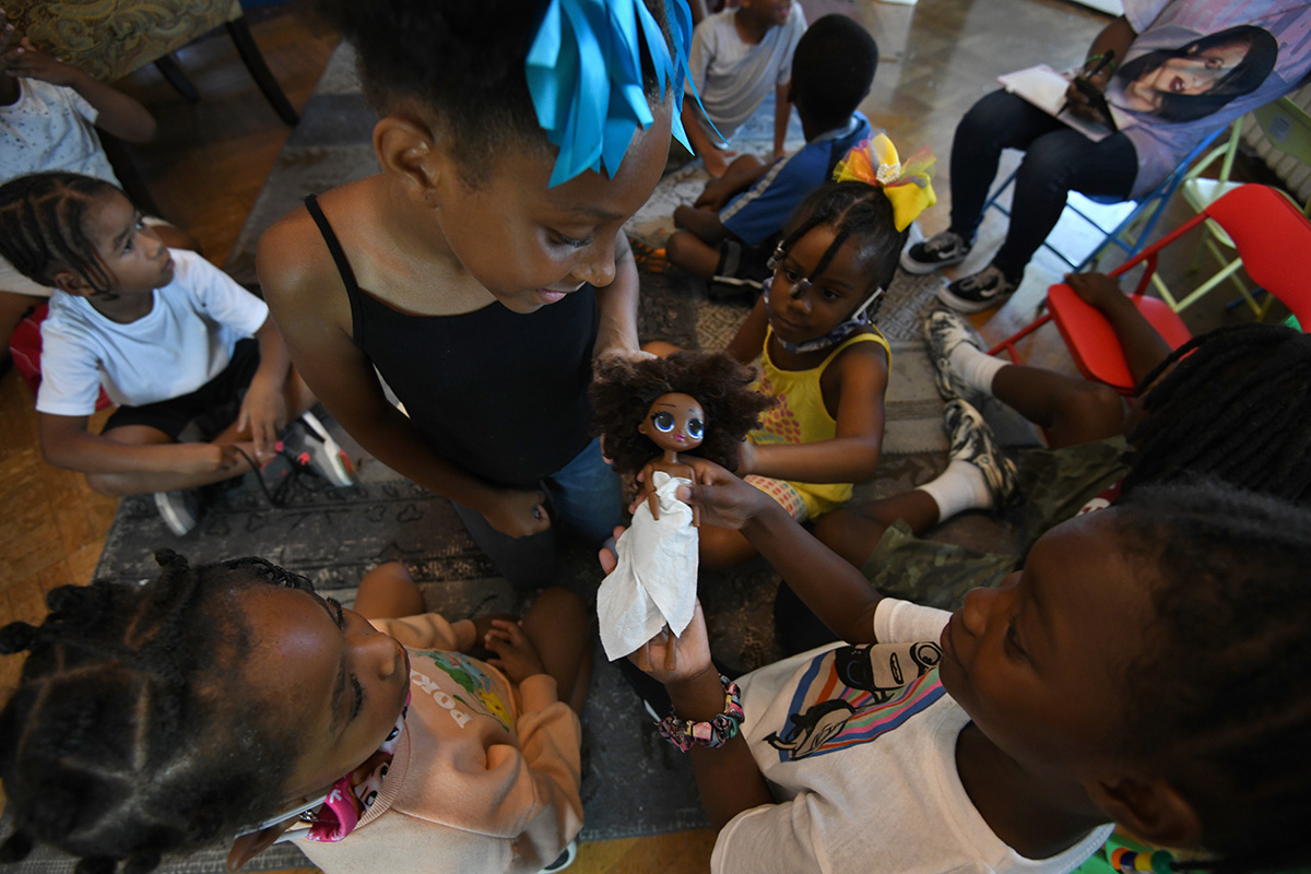 kids looking at a doll