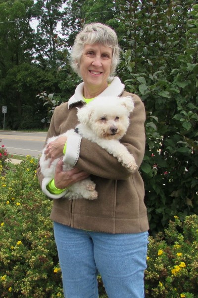 photo of a woman holding a white dog