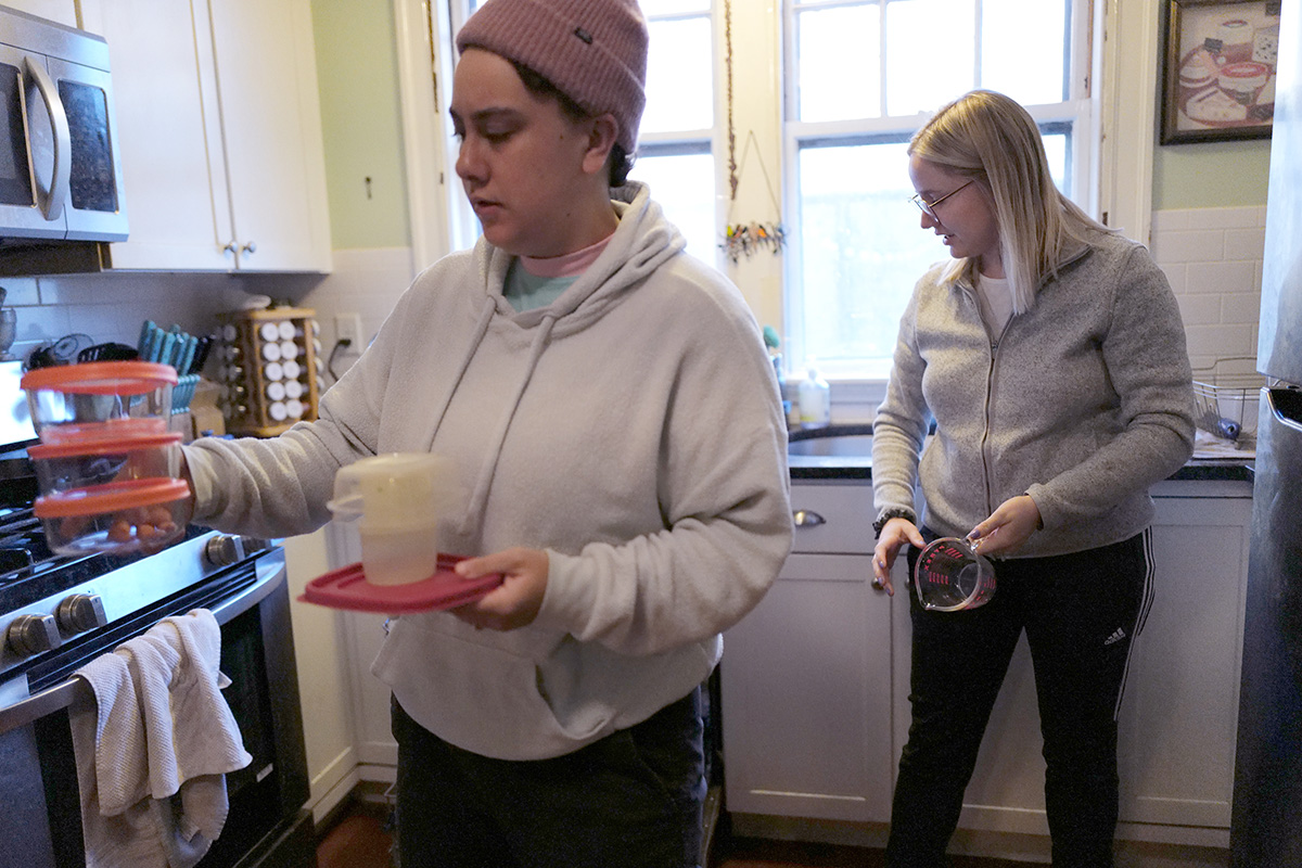 Rebekah Shore (left) and Jamie Shore (right), residents of Emmanuel House in Allston, Mass. clean the house’s kitchen after morning prayer on Nov. 21, 2022.