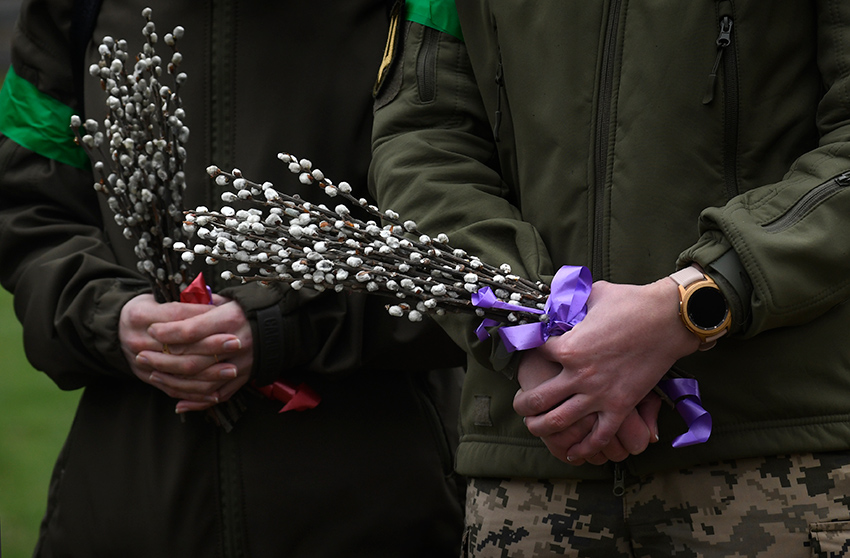 people hold bouquets of willow branches