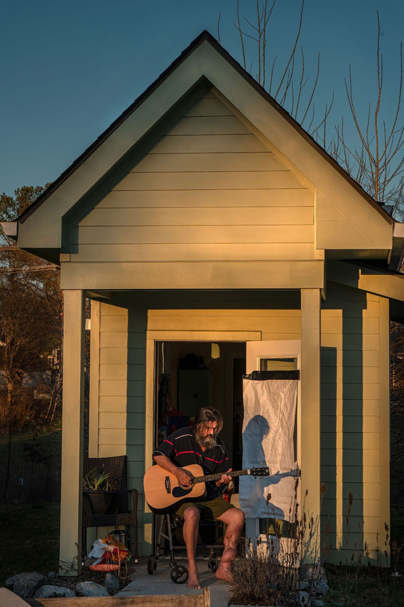 man on porch of tiny home