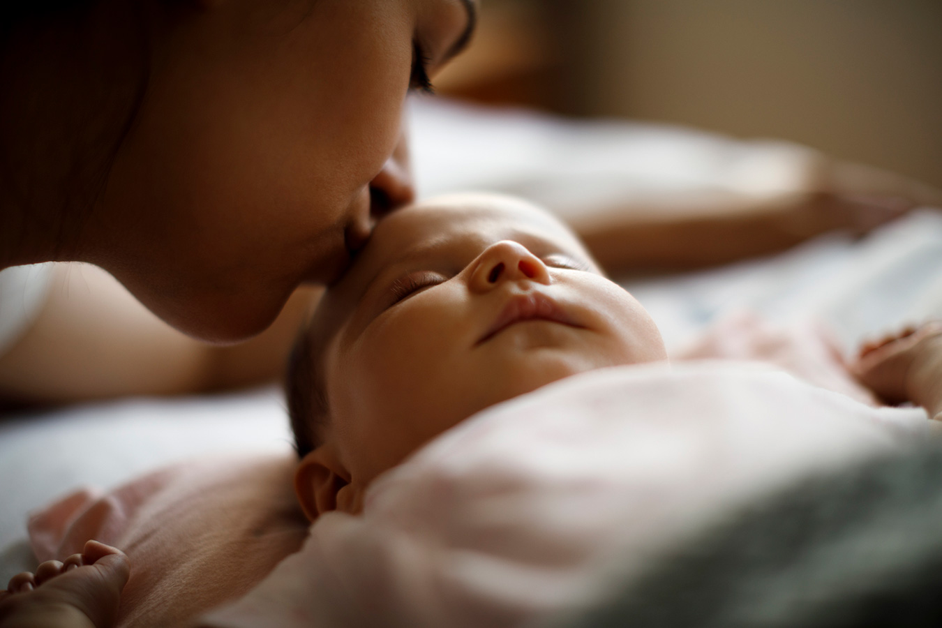 A person kissing a newborn baby