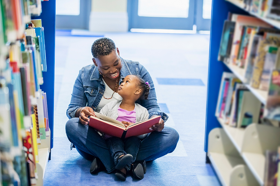 Parent reading to child in the library