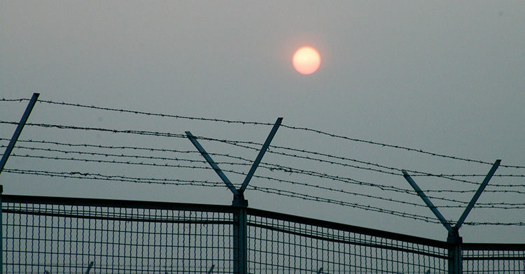 sun over a prison fence