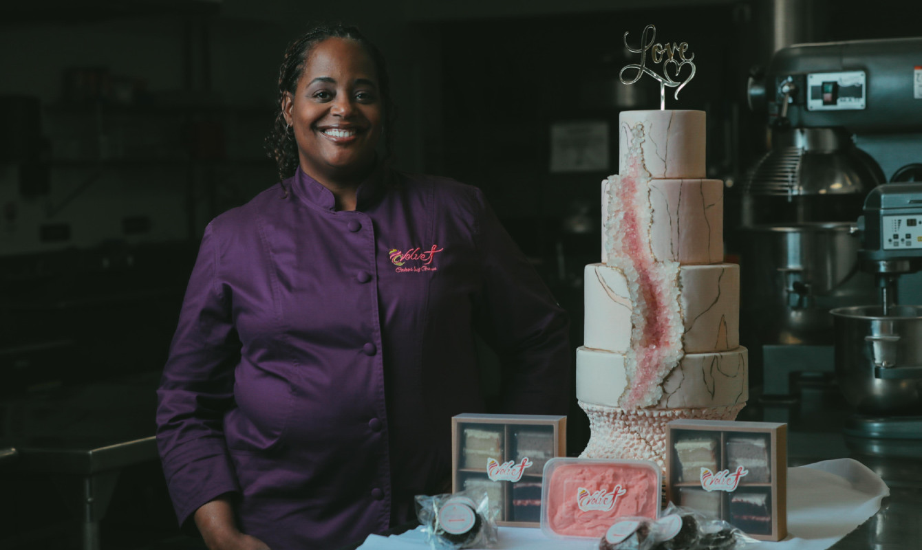 Image of a woman standing with a four-tiered cake