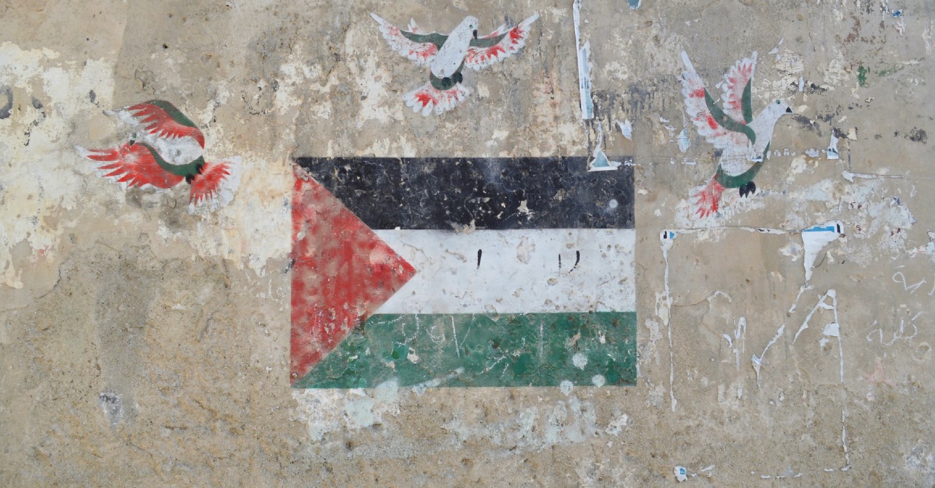 Image of a Palestinian flag and doves painted on a wall