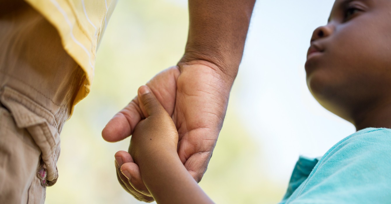 Image of a boy holding his father's hand