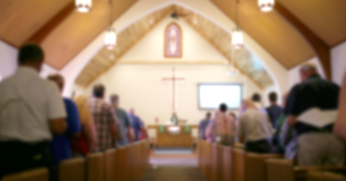 People in a church sanctuary photographed from behind