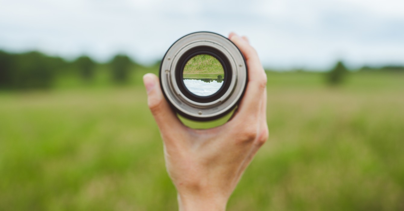 Image of a hand holding a camera lens