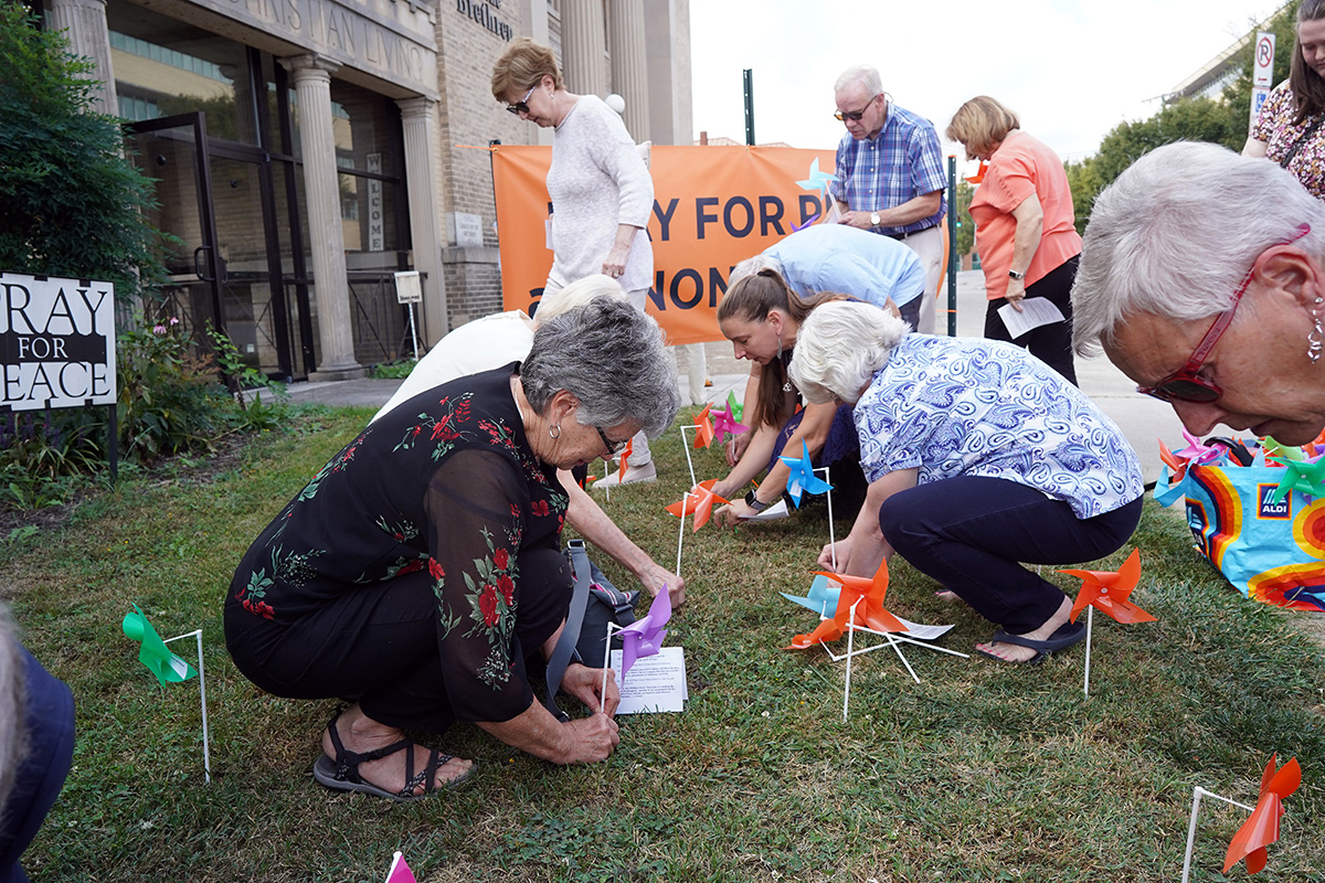 Church members install pinwheels for the 'Pinwheels for Peace Project" at the Church of the Brethren.