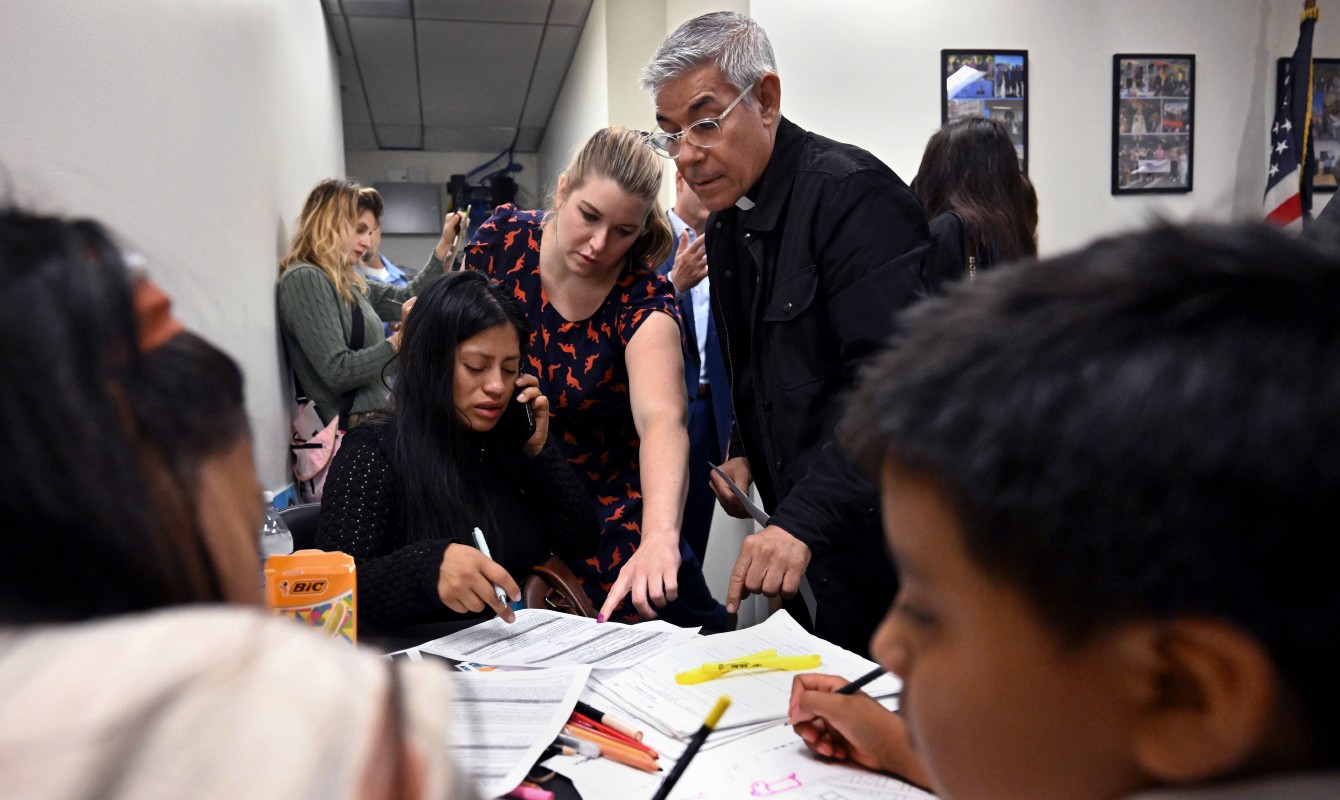 A photo of a pastor helping someone with paperwork