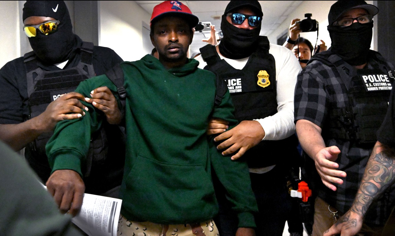 Photo of a man being detained by ICE