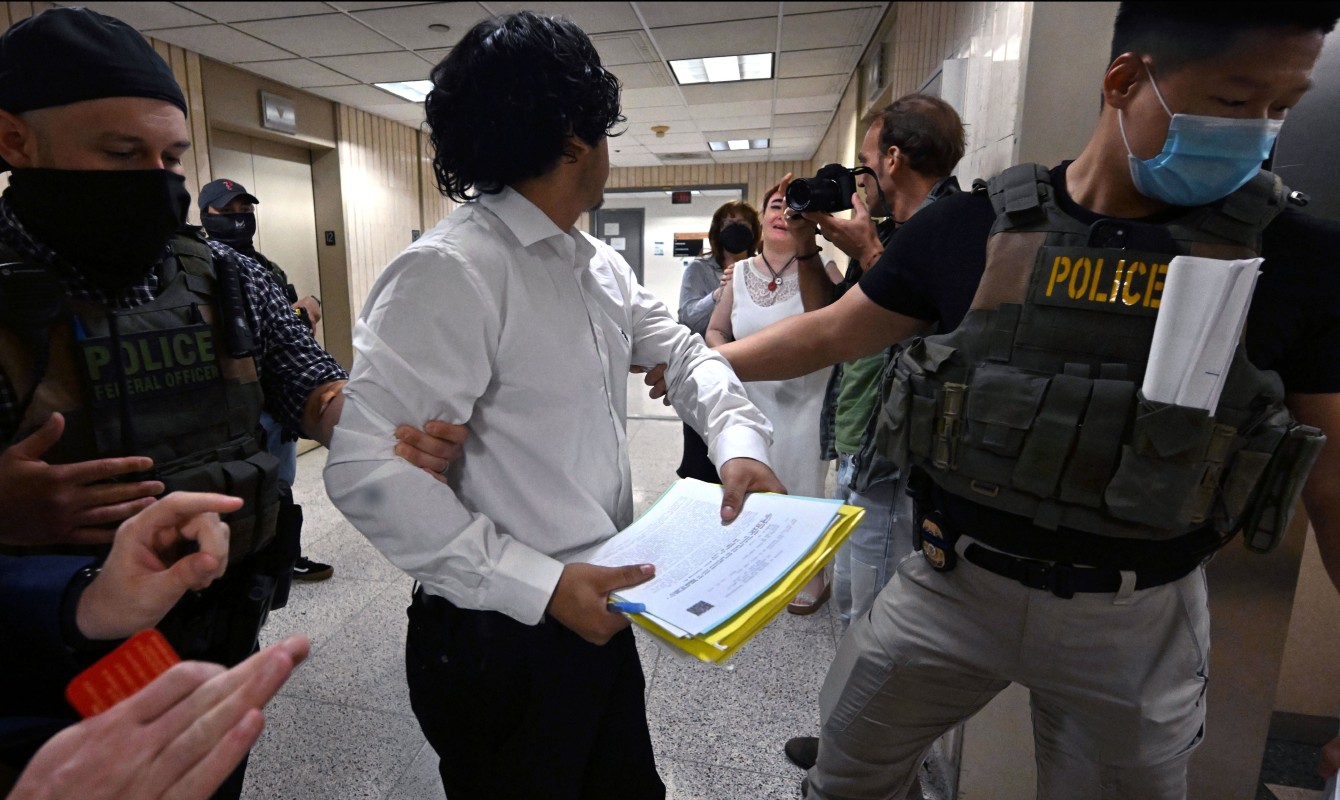 Photo of a man being taken by ICE