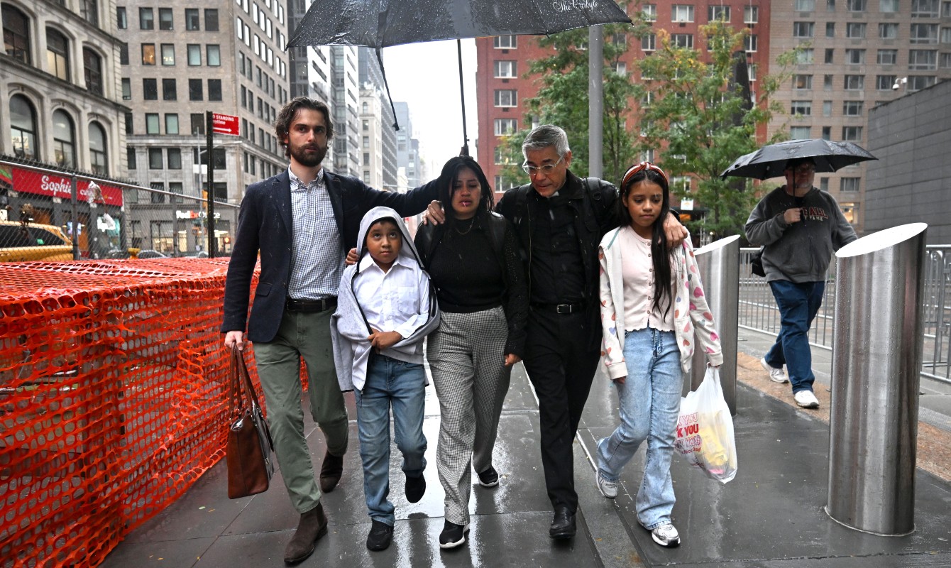 Photo of a family walking in the street under an umbrella