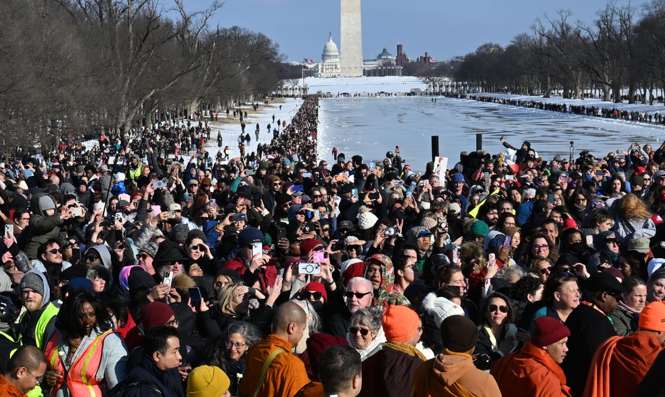 Photo of a crowd greeting monks in front of Washington Memorial