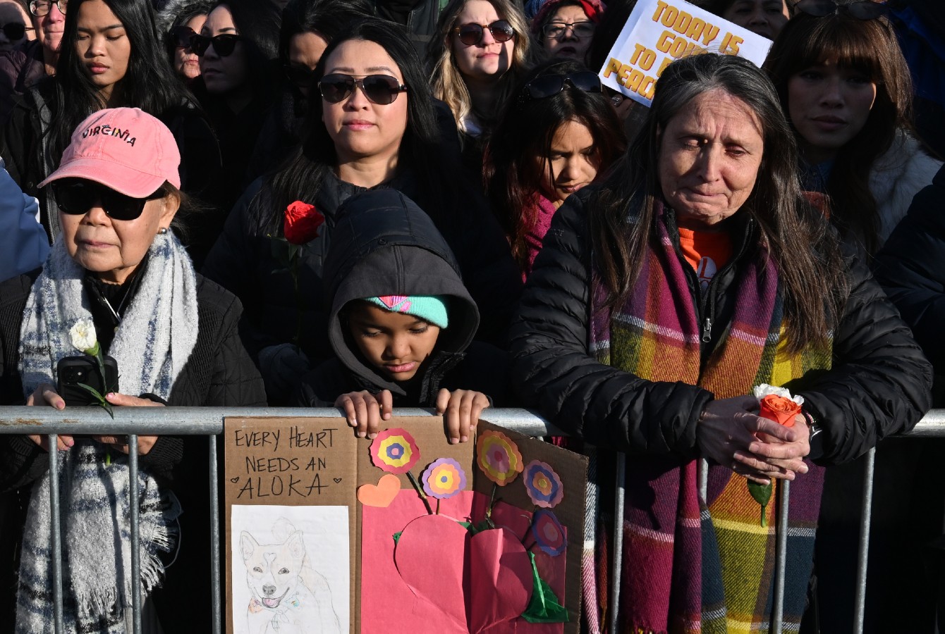 Photo of a girl holding a sign in a crowd