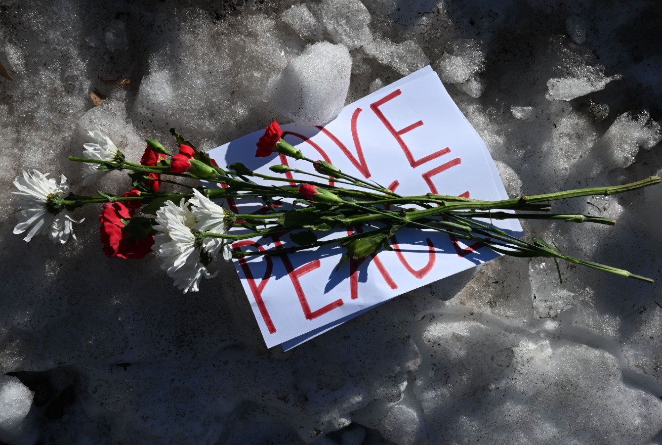 Photo of a bouquet on a sign that says "Love Peace"