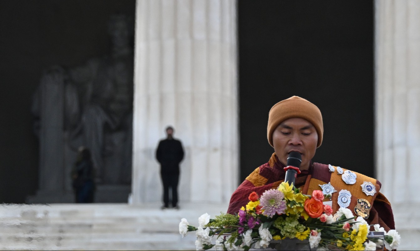 Photo of a monk speaking in front of the Lincoln Memorial