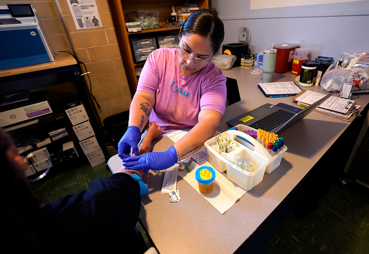 A nurse draws blood from a patient