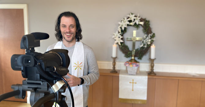 Pastor stands behind video camera