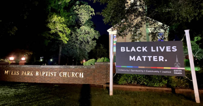 Black Lives Matter sign stands next to the sign for the Myers Park Baptist Church