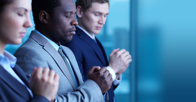 Three business people praying