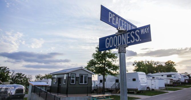 Street corner of Goodness Way and Peaceful Path; RVs and tiny house in background