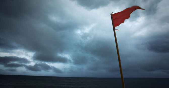 Red flag on a stormy beach