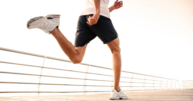 Legs of a man running on a bridge