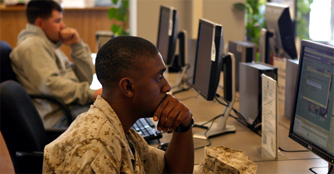 Soldier in uniform looking at a computer screen